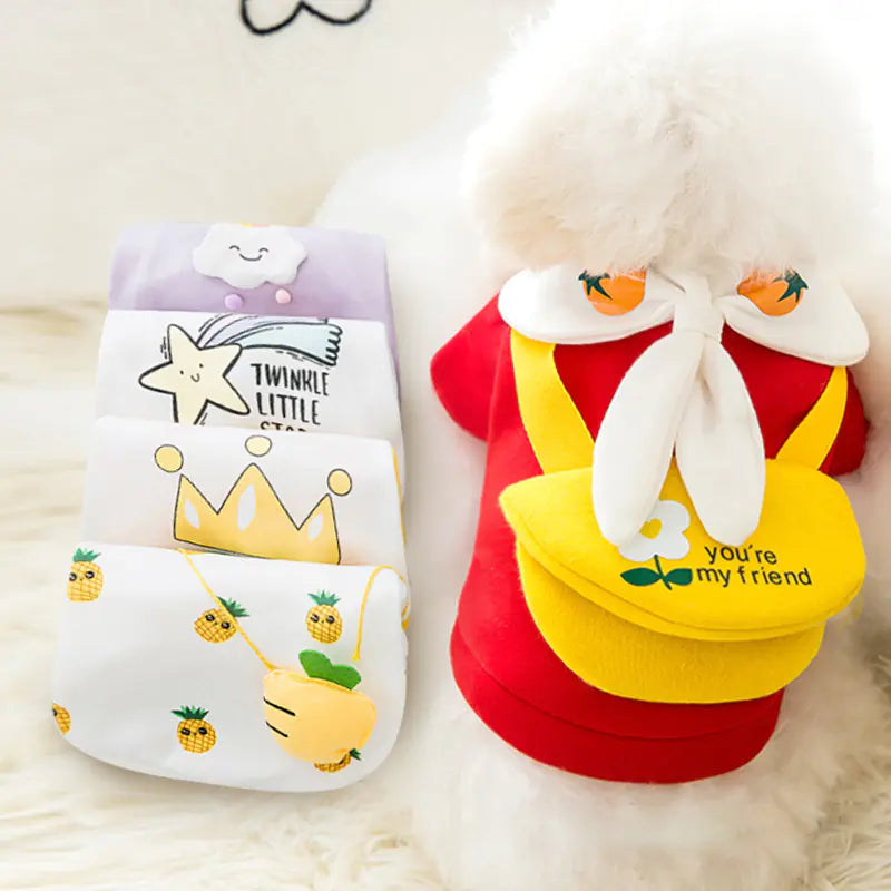 Two cartoon-themed dog outfits on a fluffy white surface.