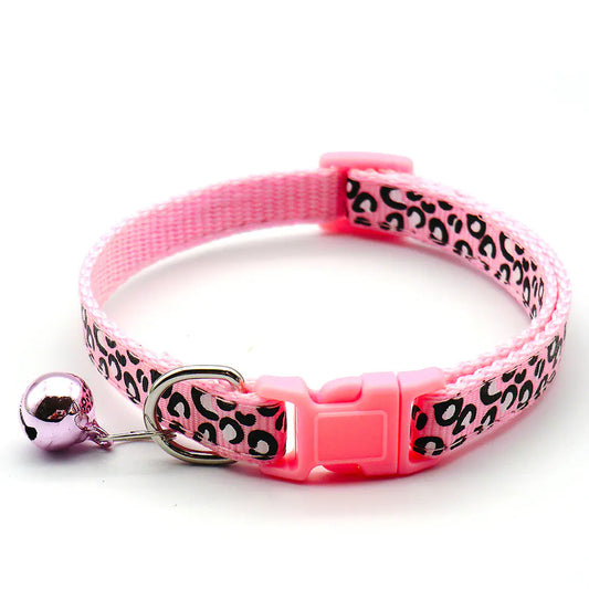 Pink cat collar with leopard print pattern and bell on a white background