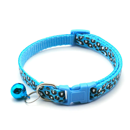 Blue cat collar with black leopard print pattern and bell on a white background