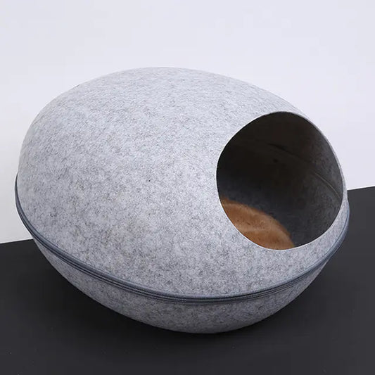Light grey eggshell-shaped felt cat bed with semi-enclosed design