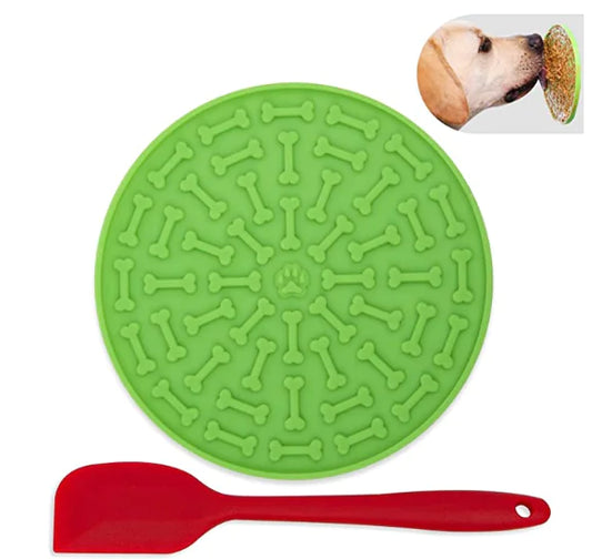 Green silicone mat with bone pattern and red spatula on a white background